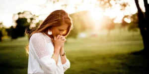 십이신살 육해살 - 한 여인이 햇살이 좋은 공원으로 보이는 곳에서 기도를 하고 있습니다.